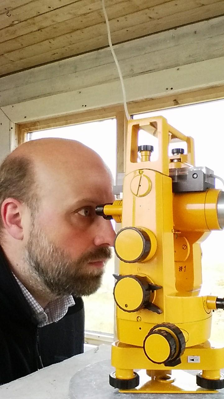 Magnar Gullikstad Johnsen gjør en absoluttmåling på Bjørnøya med en landmålingskikkert. Absoluttmålingene brukes til å kalibrere magnetometerne forskerne har, slik at de også gir riktige verdier av magnetfeltet