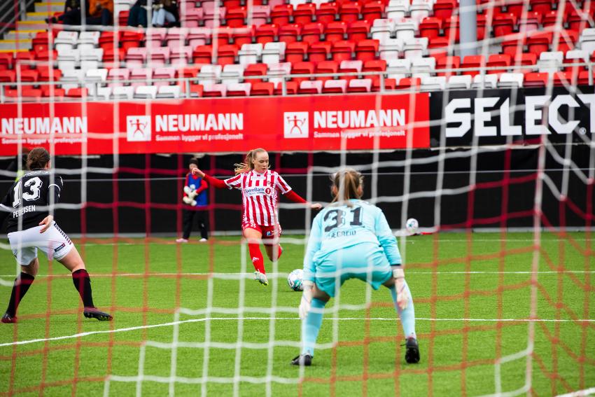 dame som skyter en fotball mot et mål 