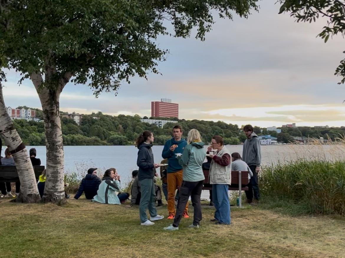 Persons standing in front of a lake