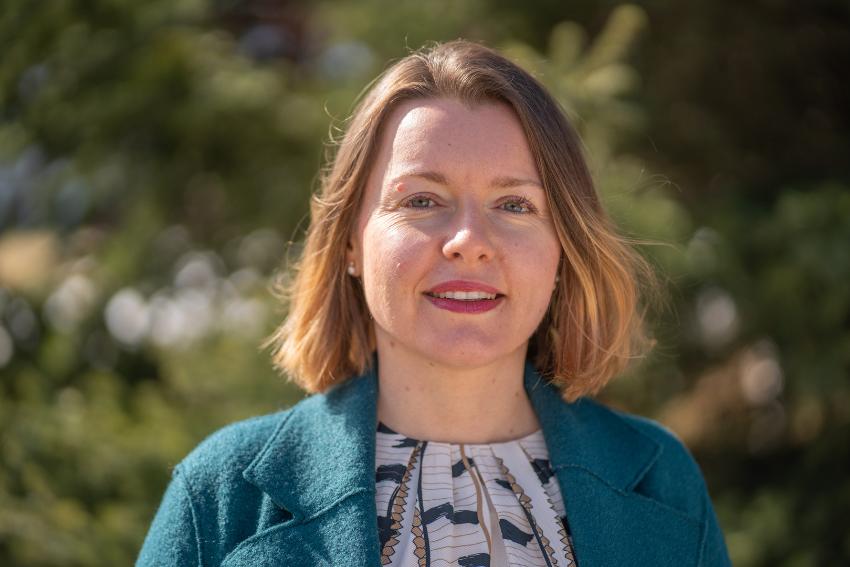 kvinne ser i kamera, kort h&aring;r, smiler